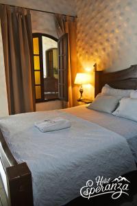 una camera da letto con un grande letto bianco con uno specchio di Hotel Esperanza Estelí a Estelí Altre 39 foto