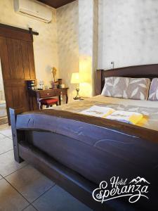 un letto grande in una stanza con una scrivania e un letto sidx sidx di Hotel Esperanza Estelí a Estelí