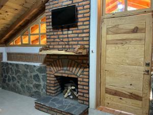 a brick fireplace with a television on top of it at Cabaña La Joyita By GEstores in Huasca de Ocampo
