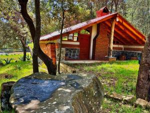a small brick house with a rock in front of it at Cabaña La Joyita By GEstores in Huasca de Ocampo