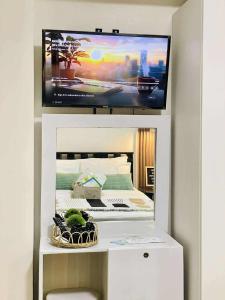 a bedroom with a tv on top of a bed at SM Bicutan Staycation by Urban Suite in Manila