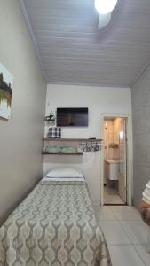 a bedroom with a bed and a kitchen in it at Loft Caminho do Mar in Angra dos Reis