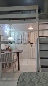 a kitchen with a table and a refrigerator in it at Loft Caminho do Mar in Angra dos Reis +3 photos