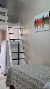 a room with a bed and a ladder next to a wall at Loft Caminho do Mar in Angra dos Reis