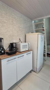 a kitchen with a white refrigerator and a microwave at Loft Caminho do Mar in Angra dos Reis