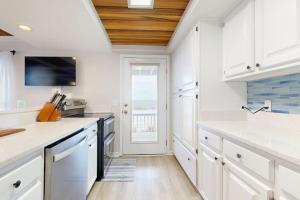 a kitchen with white cabinets and a large window at KC's Seaside Sanctuary in Edisto Island