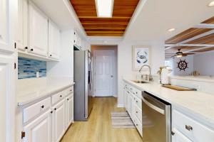 a kitchen with white cabinets and a refrigerator at KC's Seaside Sanctuary in Edisto Island