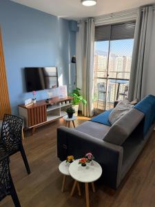 a living room with a couch and a tv at Conforto e Localização perfeita Centro RJ 20 min Copacabana e Piscina in Rio de Janeiro