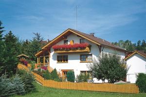 ein großes weißes Haus mit Blumen an den Fenstern in der Unterkunft Ferienwohnungen Malz in Blaibach