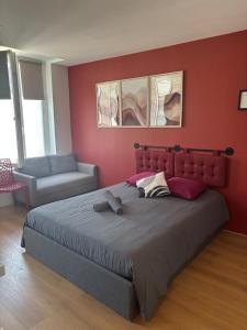 a bedroom with a large bed and a chair at Terra Cotta 1er Étage in Abbeville