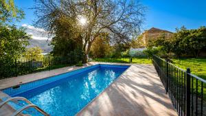 a swimming pool in a yard with a fence at El Remanso de Marie in Órgiva