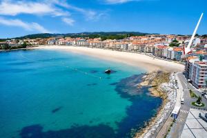 an aerial view of a beach with a boat in the water at Hotel Casa Román in Sanxenxo