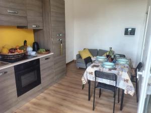 a small kitchen with a table with chairs and a couch at Borgo antico Pisa in Montecastello