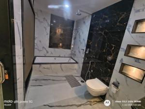 a bathroom with a tub and a toilet and a sink at Asusss International in New Digha +20 photos