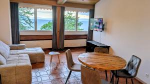 a living room with a couch and a table at Chillon lake view by MK in Montreux