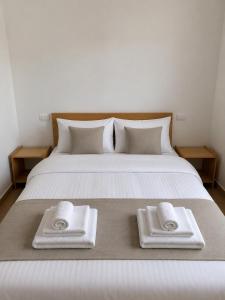 a bed with two towels sitting on top of it at Davidovic House in Amzići