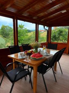 a wooden table with a bowl of fruit on it at Davidovic House in Amzići