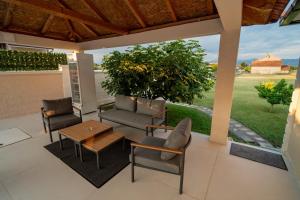 a patio with a couch and chairs and a table at Amon Private Pool Residence in Podgorica
