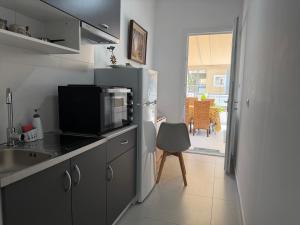 a kitchen with a microwave and a refrigerator at Piraeus Sea Loft in Piraeus