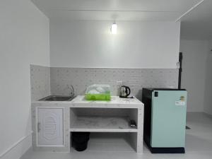 a small kitchen with a sink and a refrigerator at อิมแพค เมืองทองธานี c8 ชั้น 13 ห้องพักรายวัน in Thung Si Kan