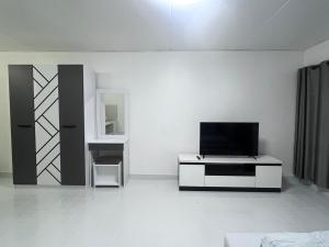 a living room with a tv on a white wall at อิมแพค เมืองทองธานี c8 ชั้น 13 ห้องพักรายวัน in Thung Si Kan
