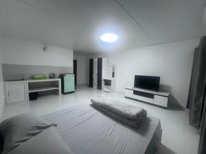 a white room with a bed and a tv at อิมแพค เมืองทองธานี c8 ชั้น 13 ห้องพักรายวัน in Thung Si Kan