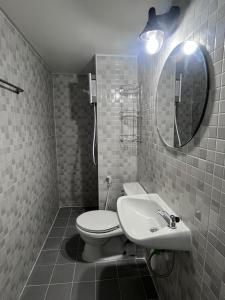 a bathroom with a toilet and a sink and a mirror at อิมแพค เมืองทองธานี c8 ชั้น 13 ห้องพักรายวัน in Thung Si Kan