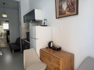 a kitchen with a white refrigerator and a wooden table at Piraeus Sea Loft in Piraeus +5 photos