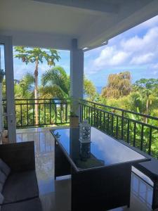 a room with a table and a balcony with a view at Royale Green Villa in Anse Royale