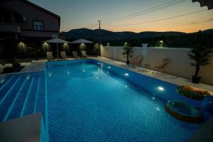 a large blue swimming pool in a backyard at Amon Private Pool Residence in Podgorica
