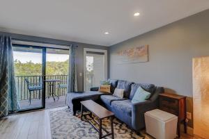 a living room with a blue couch and a balcony at HH Beach & Tennis 226C in Hilton Head Island