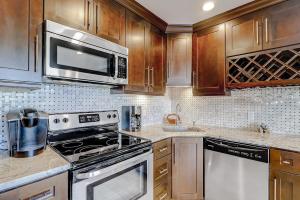 a kitchen with stainless steel appliances and wooden cabinets at HH Beach & Tennis 226C in Hilton Head Island +22 photos
