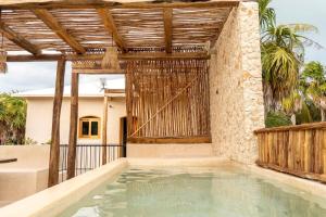 an outdoor swimming pool with a wooden pergola at Villa Hydra Private Villa with Rooftop Pool in El Cuyo