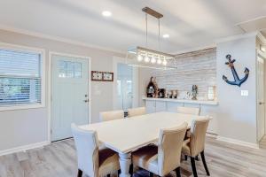 a kitchen and dining room with a white table and chairs at Barefoot Lizzy's in Edisto Island