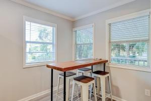 a kitchen with a table and two stools and two windows at Barefoot Lizzy's in Edisto Island