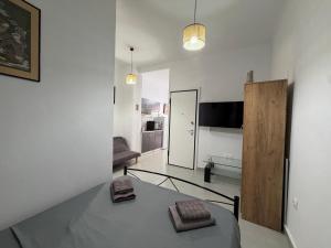 a white room with a bed and a living room at Piraeus Sea Loft in Piraeus