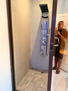 a man is taking a picture of a shower door at Diana's Place Guest house in Nyanda