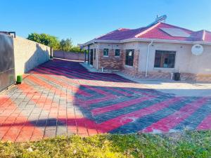 a house with a colorful rug on the driveway at Diana's Place Guest house in Nyanda