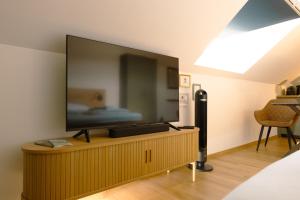 a flat screen tv sitting on top of a wooden cabinet at Geidorf Residenz - Serviced Apartments & Parking in Graz