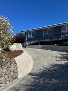 a road in front of a house with a building at Ocean Vista Hideaway in Kaikoura +6 photos