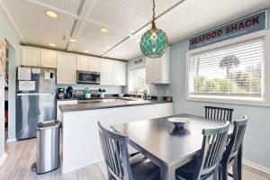 a kitchen with a table and chairs and a refrigerator at Breath'n Easy in Edisto Beach