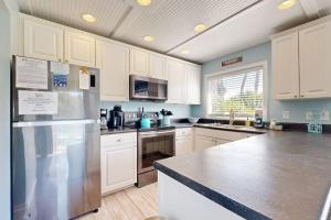 a kitchen with white cabinets and a stainless steel refrigerator at Breath'n Easy in Edisto Beach