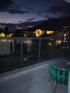 a balcony with a table and a chair at night at Mare Ann in Ljubuški