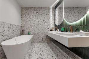 a white bathroom with two sinks and a tub at Spatium Medical & Wellness Hotel in Odesa