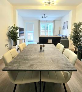 a dining table and chairs in a living room at Luxury Flat 10 mins from Station with BIKE ! in Cambridge +2 photos
