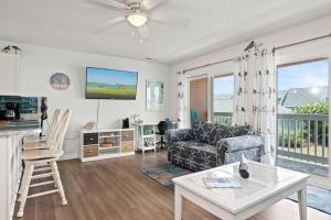 a living room with a couch and a table at Pebble Beach I-211 in Emerald Isle