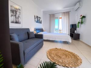 a living room with a couch and a bed at Billys studios in Karistos