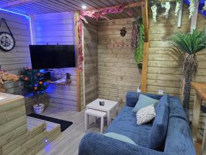 a living room with a blue couch and a tv at Gite de yaya in Cousance