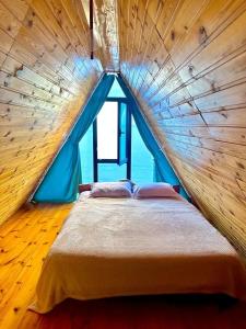 a bed in a wooden room with a large window at Marco Polo Sarpi in Batumi