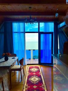 a living room with a large window with blue curtains at Marco Polo Sarpi in Batumi